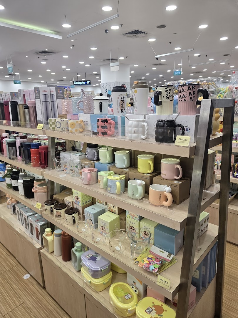 Shelves displaying a vibrant collection of mugs, tumblers, and lifestyle accessories inside POPULAR Bookstore.