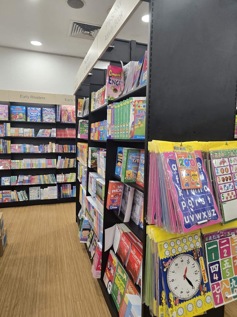 An aisle in POPULAR Bookstore featuring shelves of books, early readers, and educational activity materials.