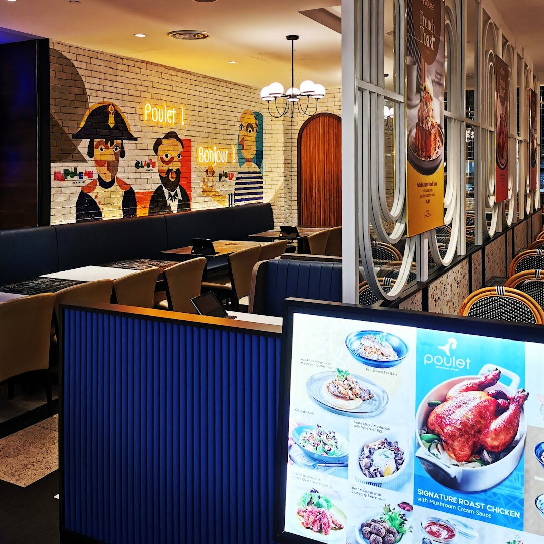 The inviting interior of Poulet restaurant featuring French-themed decor and a digital menu display.