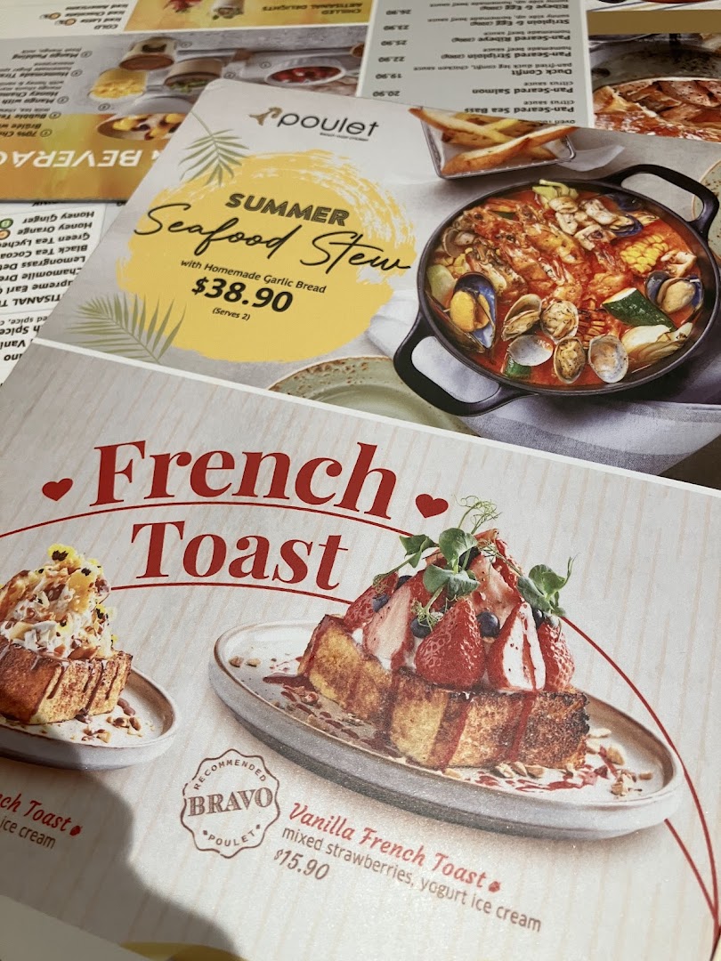 A close-up of Poulet's menu, showcasing their Summer Seafood Stew and French Toast dishes.