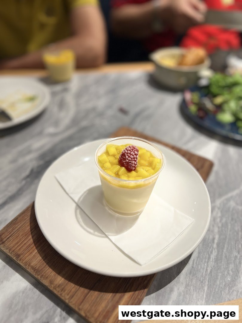 A delightful mango panna cotta dessert with a raspberry garnish served on a white plate.