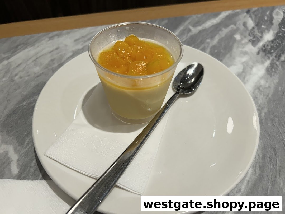 A creamy dessert topped with diced mango, served on a white plate with a spoon.