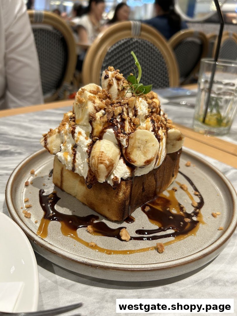 A decadent banana toast dessert with whipped cream, chocolate, and nuts on a plate in a restaurant setting.