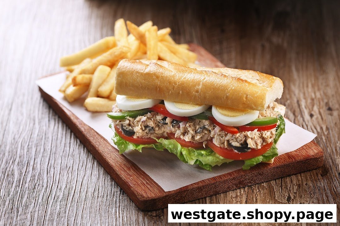 A delicious tuna baguette sandwich with hard-boiled eggs and vegetables, served with golden french fries.