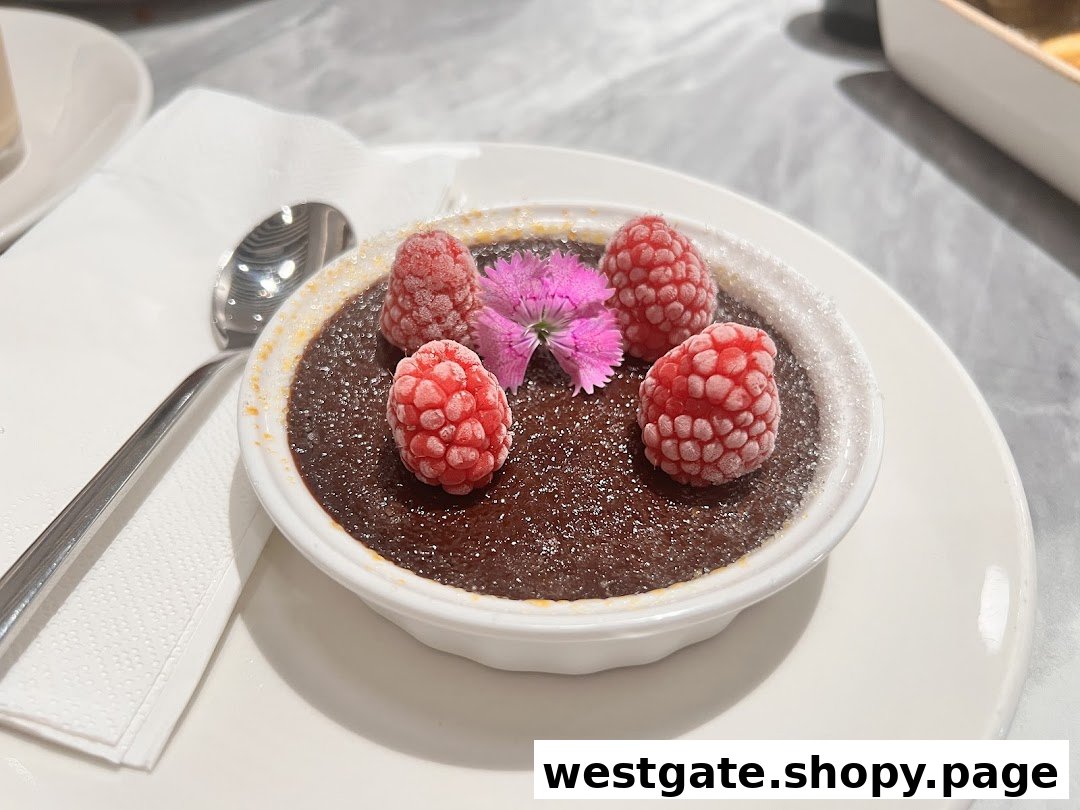 A rich chocolate dessert topped with frosted raspberries and a delicate pink flower, served on a white plate.