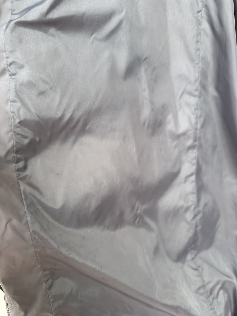 Close-up of a light-colored fabric, possibly a garment, showing subtle marks or stains.