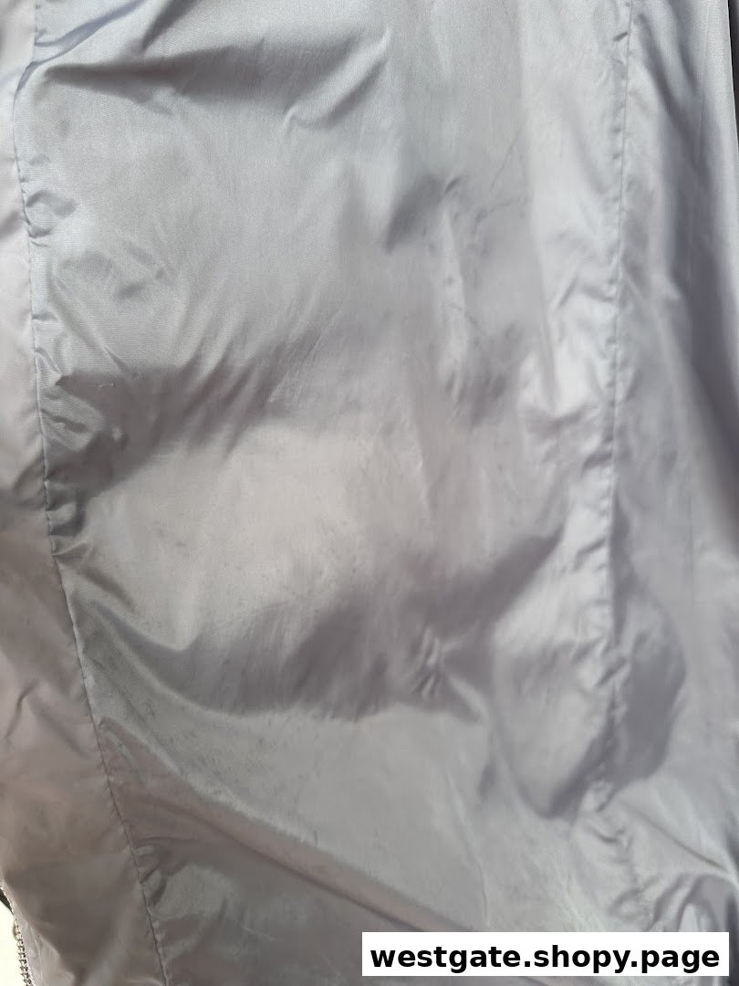 Close-up of a light-colored fabric, possibly a garment, showing subtle marks or stains.