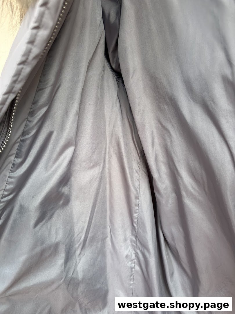 Close-up of the grey interior lining of a garment, possibly a jacket, with a zipper.