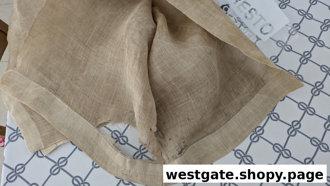 A piece of light brown fabric, possibly linen, on a patterned surface with the Presto Drycleaners logo visible.