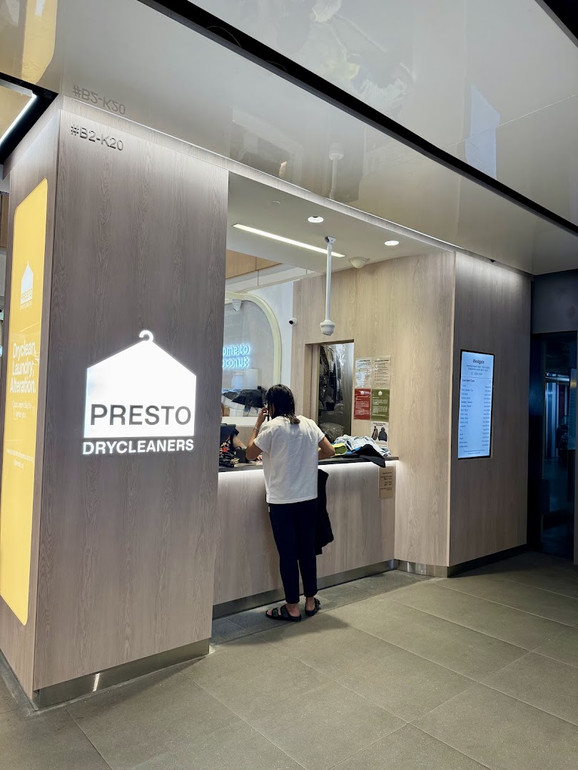 A customer at the counter of Presto Drycleaners, featuring the shop's logo and services.