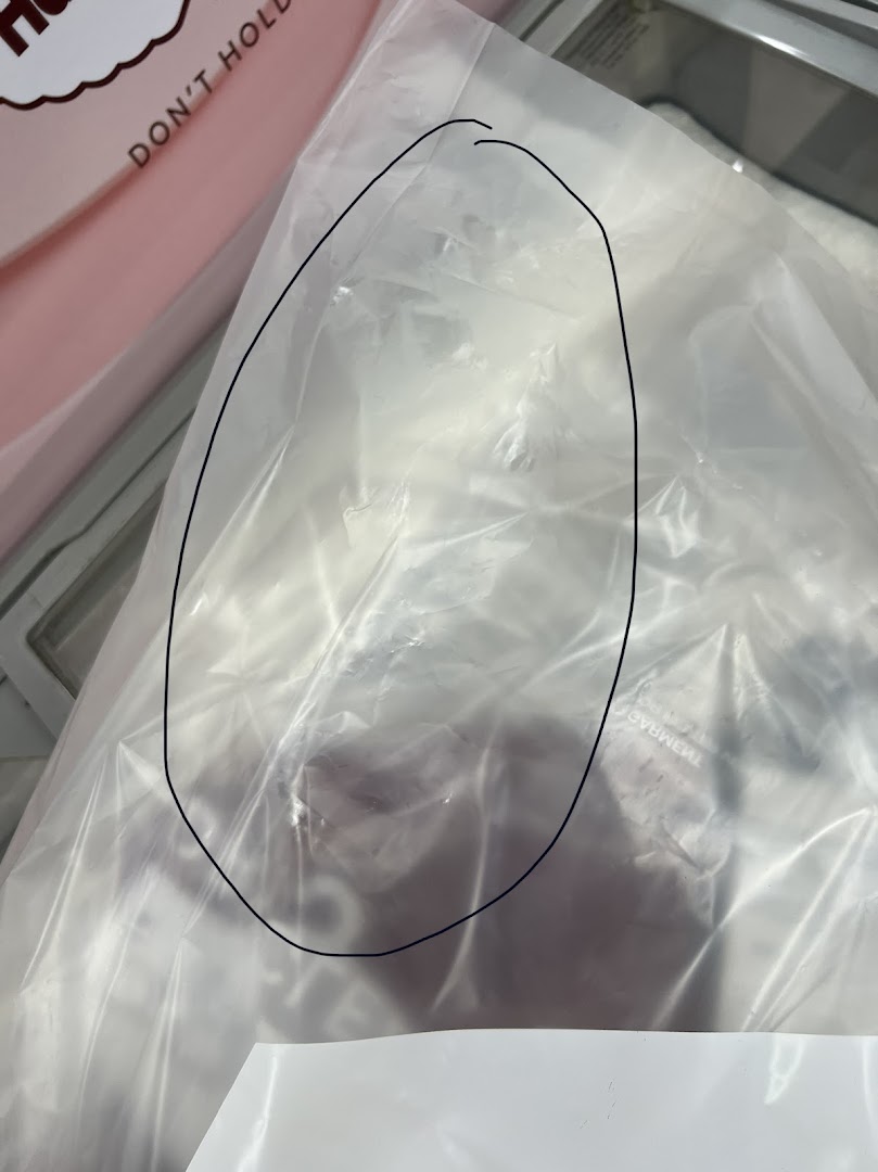 Close-up of dry-cleaned garments neatly packaged in a clear plastic bag.