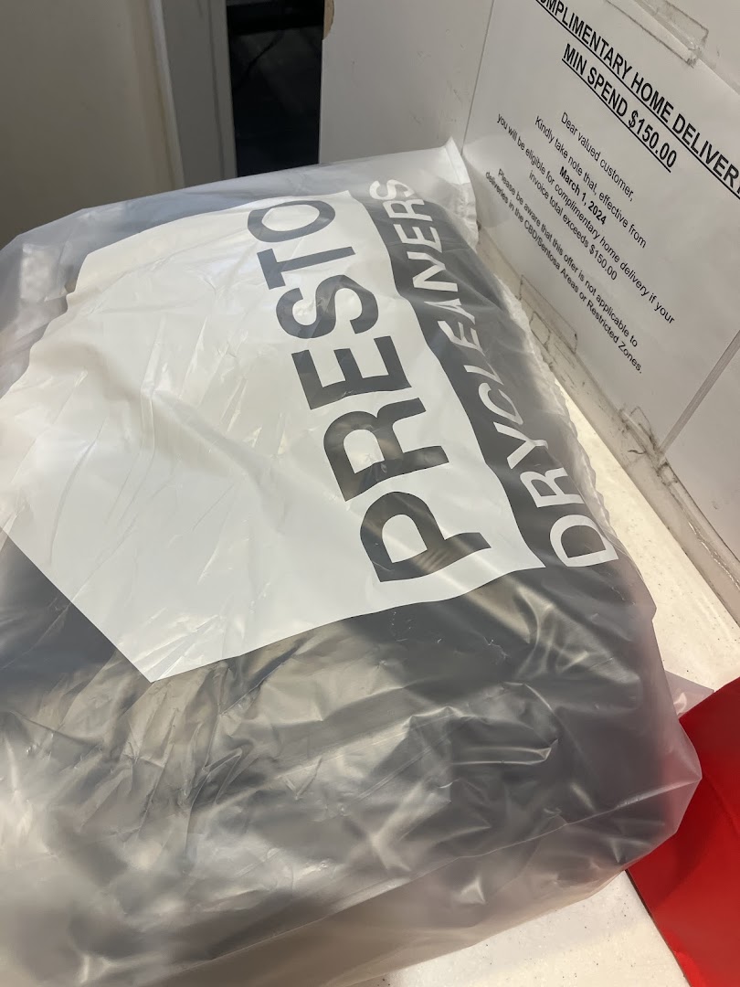 A plastic bag from Presto Drycleaners with a sign detailing a complimentary home delivery offer.