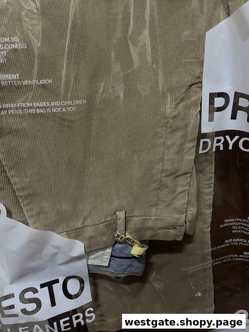 A pair of freshly dry-cleaned corduroy trousers in a clear plastic bag from Presto Drycleaners.