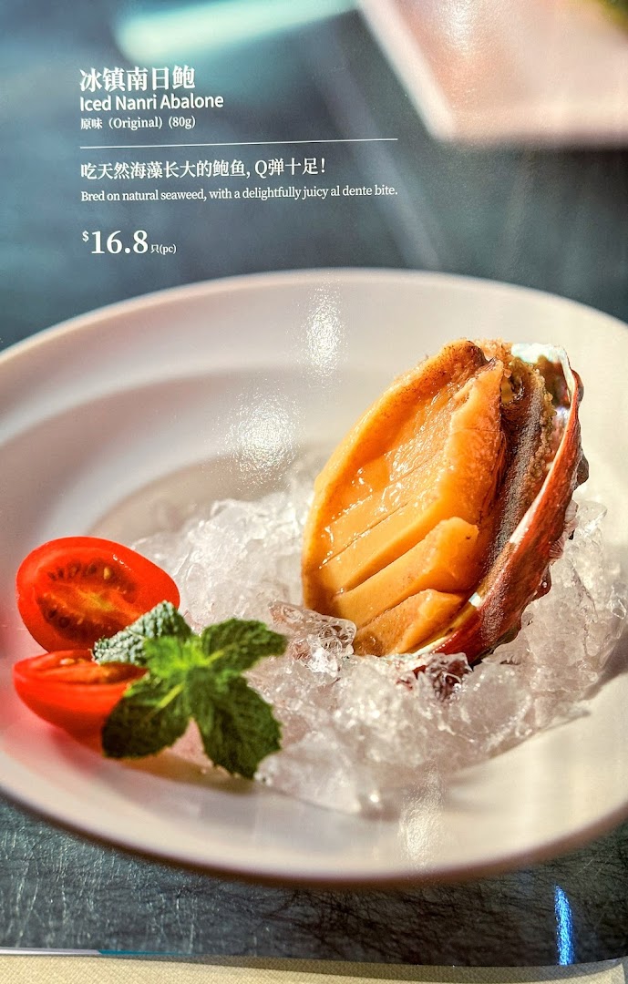 A close-up of Putien's Iced Nanri Abalone dish with its description and price on a menu.