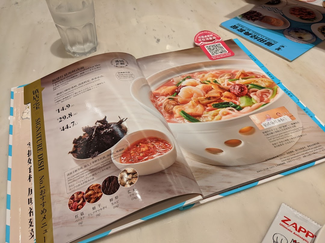An open menu displaying PUTIEN's signature Fujian Red Mushroom Seafood Lor Mee with pricing.