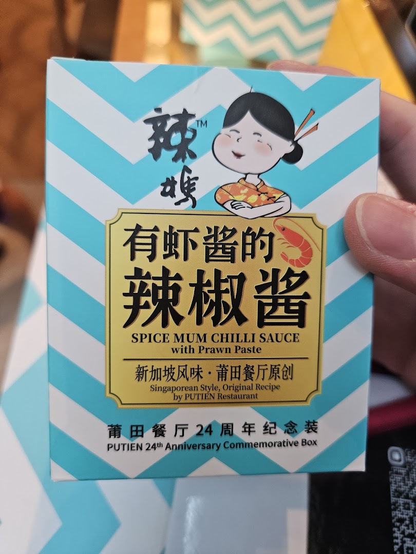 A hand holds a box of PUTIEN's Spice Mum Chilli Sauce with Prawn Paste.