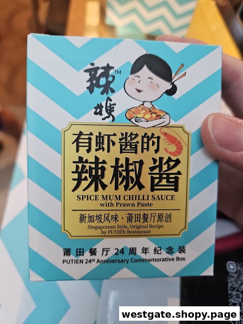 A hand holds a box of PUTIEN's Spice Mum Chilli Sauce with Prawn Paste.