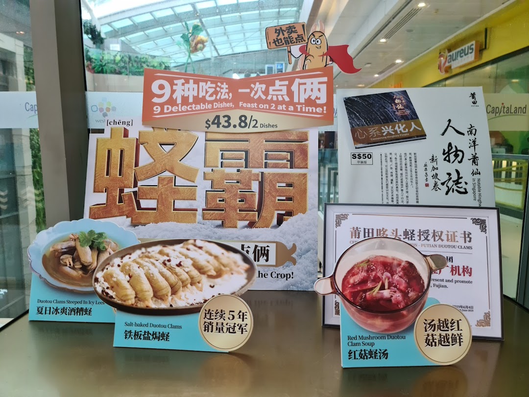 A promotional display showcasing various clam dishes and a special offer from PUTIEN restaurant.