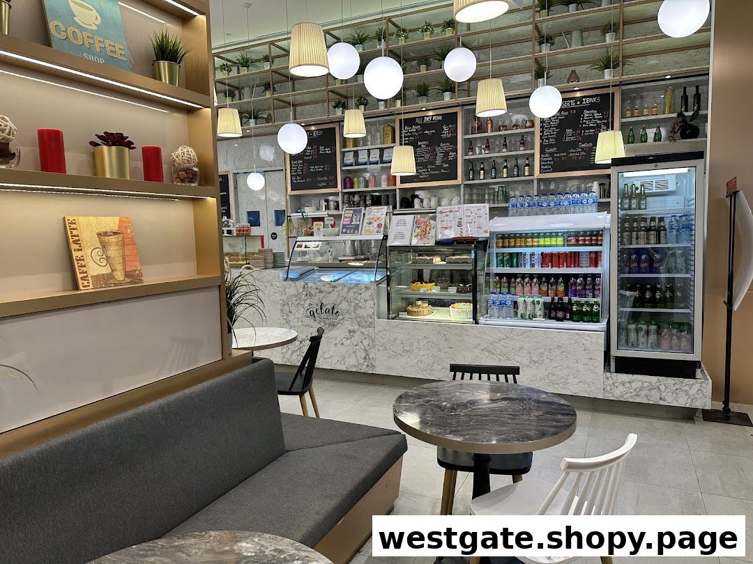 A cozy cafe interior featuring a dessert counter, various drinks, and comfortable seating.