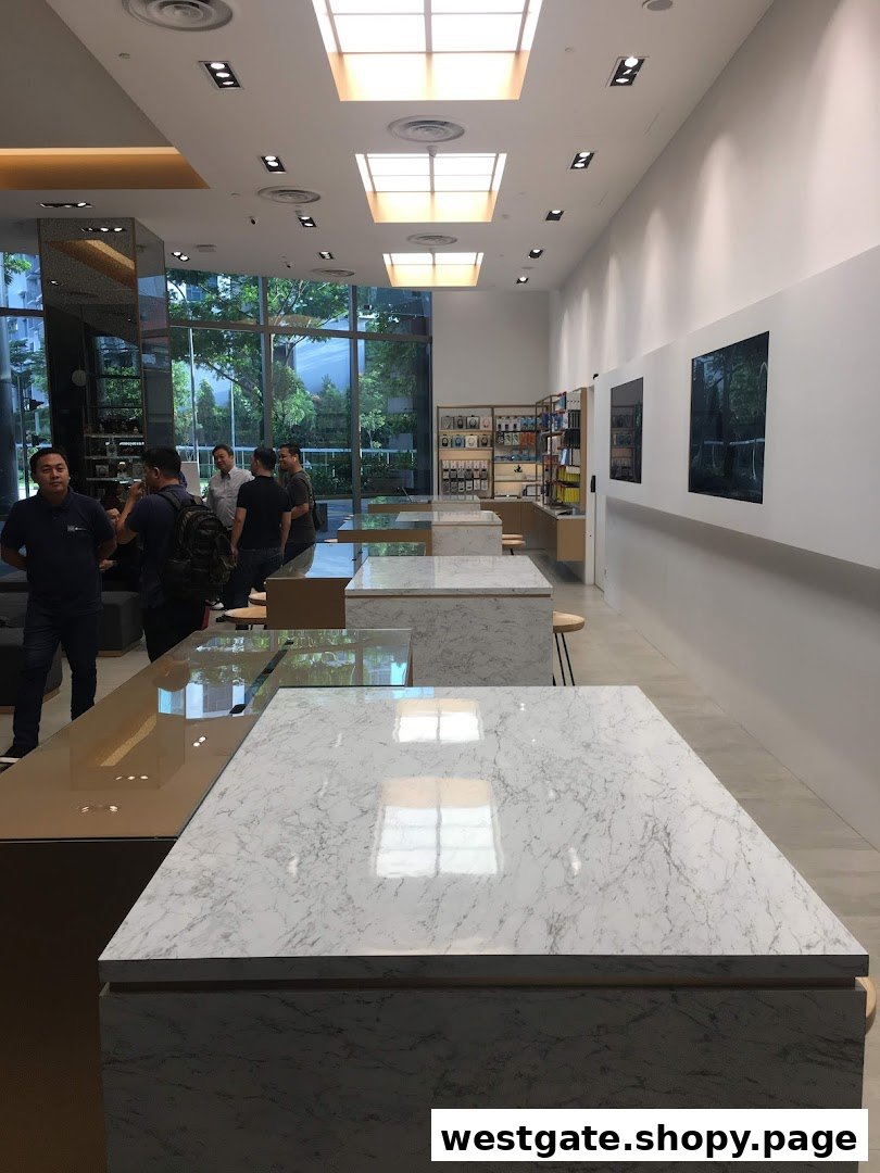 Modern retail interior with sleek display tables, large windows, and customers browsing.