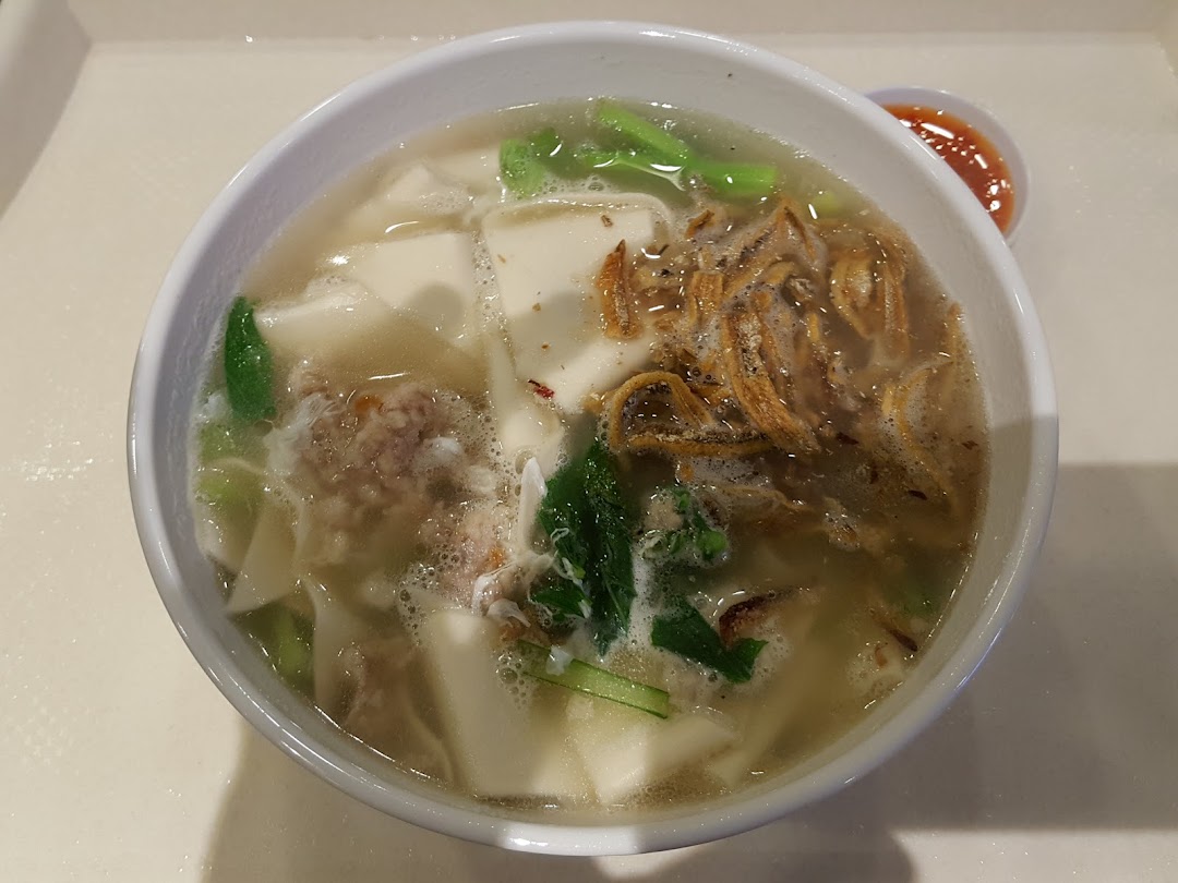 A close-up of a hearty bowl of Ban Mian with anchovies, vegetables, and minced meat.