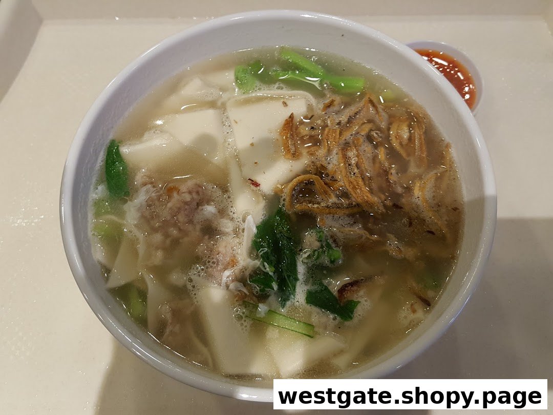A close-up of a hearty bowl of Ban Mian with anchovies, vegetables, and minced meat.