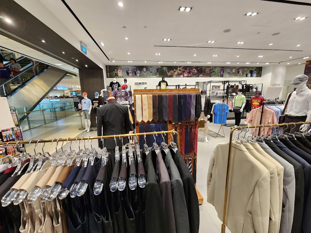 Interior view of a clothing store showcasing men's apparel, including suits, shirts, and ties on racks and mannequins.