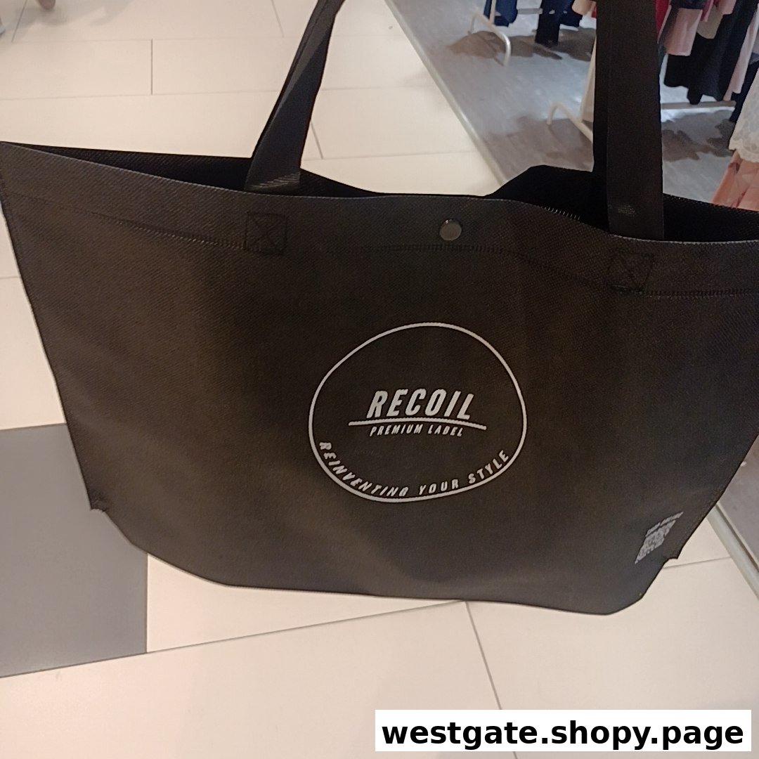 A black RECOIL shopping bag featuring the brand's logo and slogan.