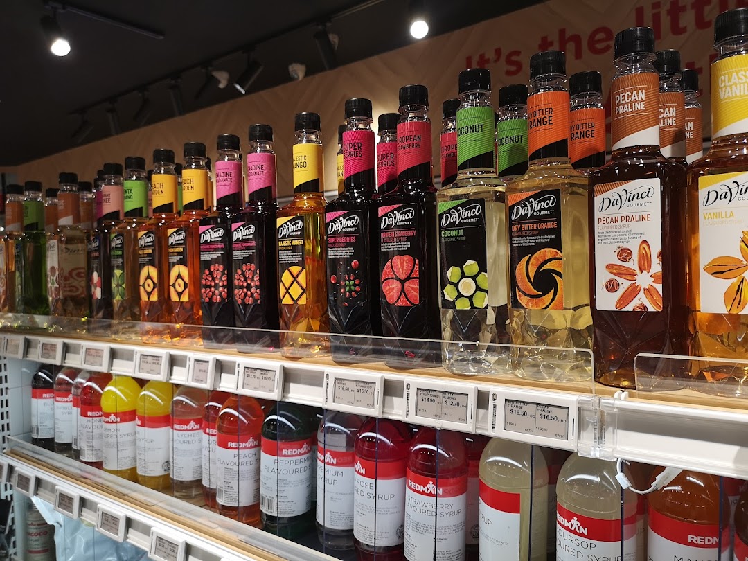 A vibrant display of DaVinci Gourmet and RedMan flavored syrups on retail shelves.