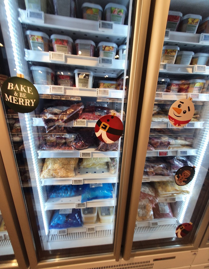 Refrigerated display cases filled with baking ingredients and products, adorned with festive Christmas decorations.