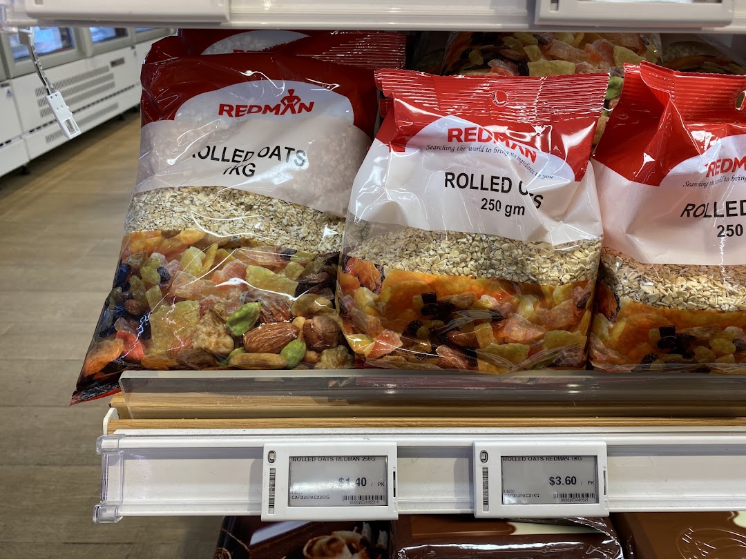 Bags of RedMan rolled oats and dried fruit mixes displayed on a retail shelf.