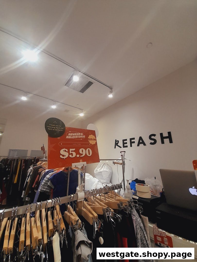 Interior view of REFASH, showcasing clothing racks, a sale sign, and the shop's name.