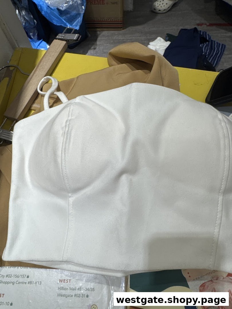 A white top displayed on a hanger inside a REFASH store, showcasing available apparel.