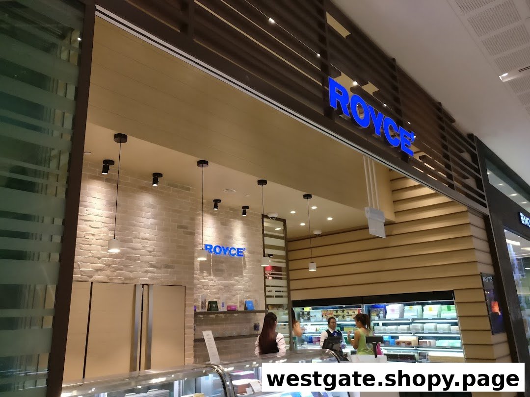 The Royce chocolate shop entrance features a modern design with a prominent blue logo and display cases.