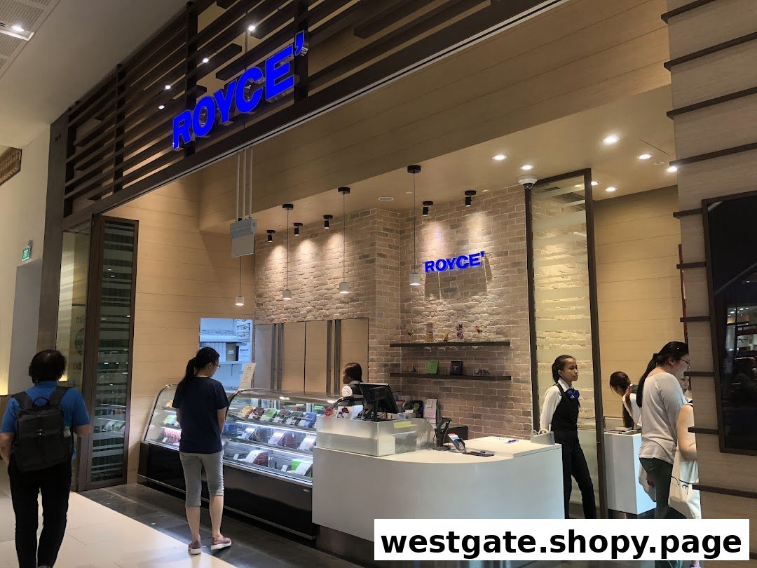 Interior view of Royce chocolate shop with customers browsing display cases and a service counter.