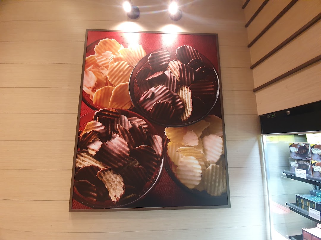 A large wall art displaying bowls of Royce's signature chocolate-covered potato chips inside the shop.