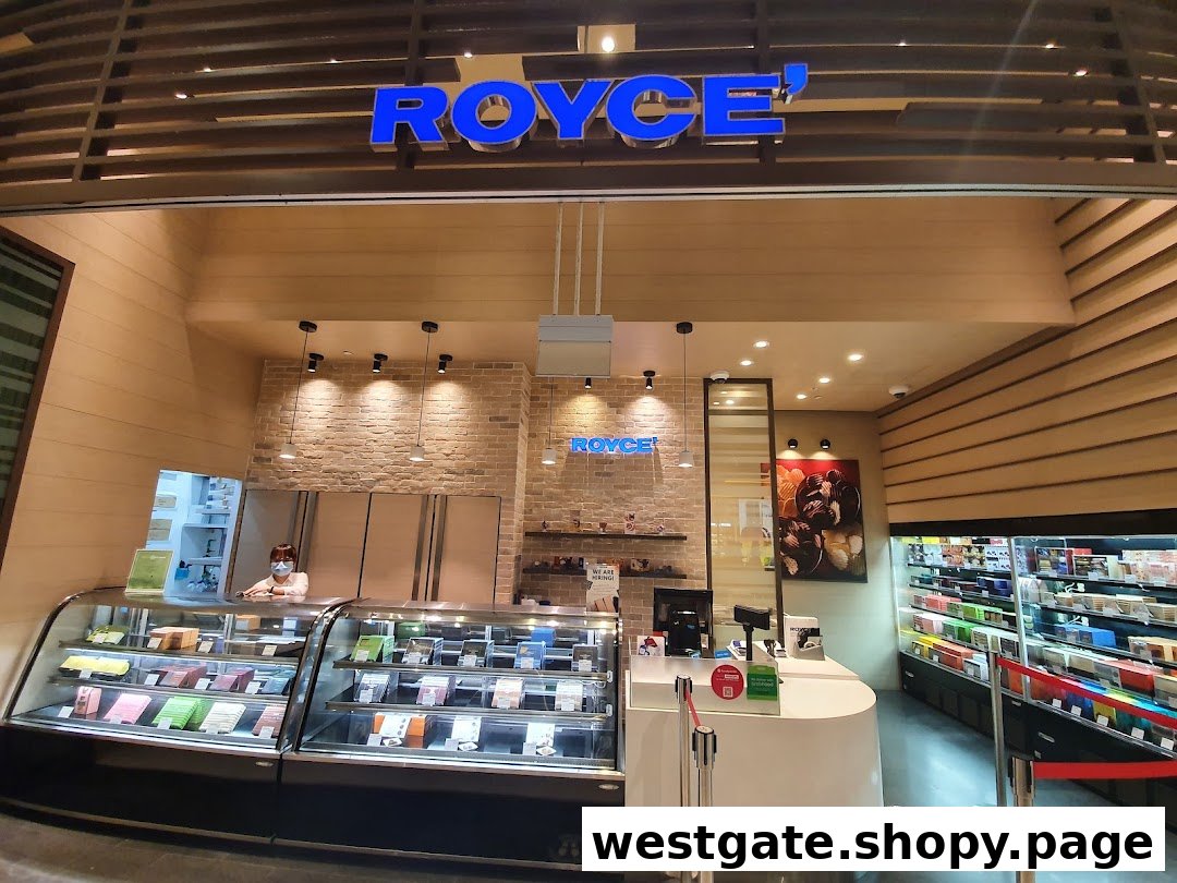 Interior view of Royce chocolate shop featuring display cases, counter, and a staff member.