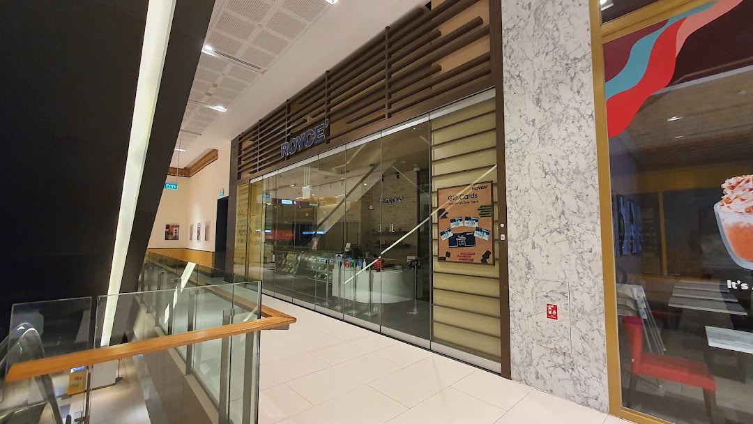 The elegant storefront of Royce', a premium chocolate shop, located within a modern shopping mall.