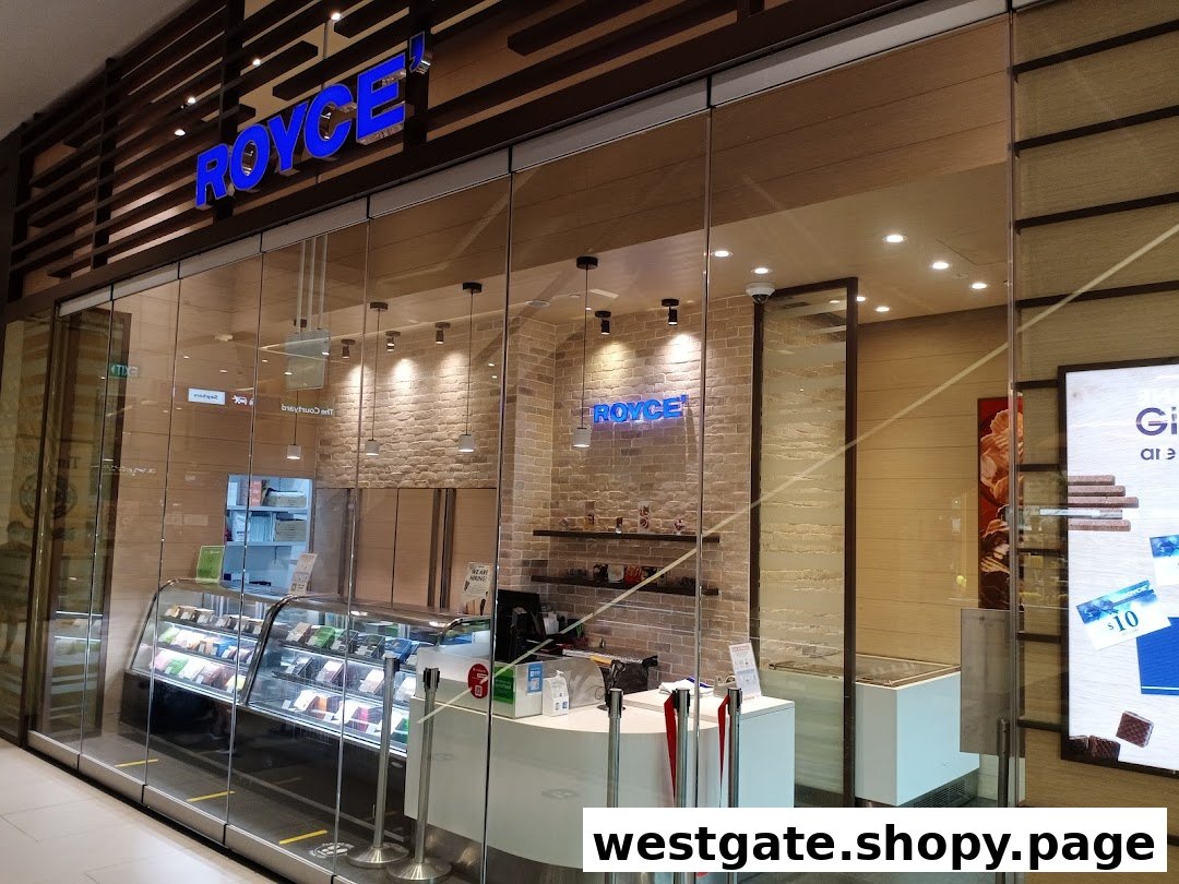 The modern storefront of Royce, a chocolate shop, featuring its blue illuminated sign and display cases.