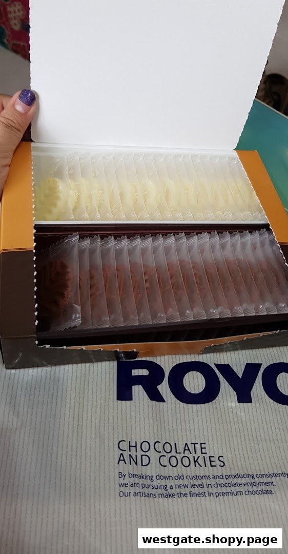 An open box of Royce chocolates and cookies, individually packaged in two varieties.