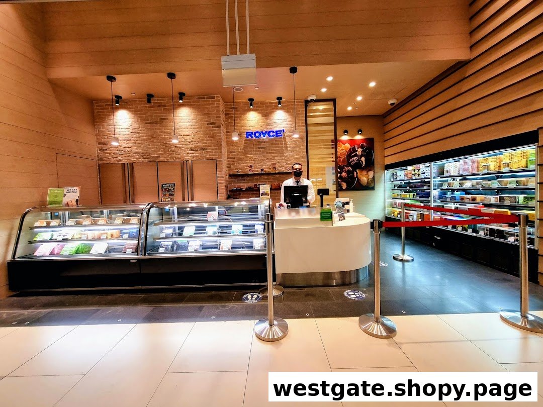Interior view of Royce chocolate shop featuring display cases, a service counter, and a staff member.
