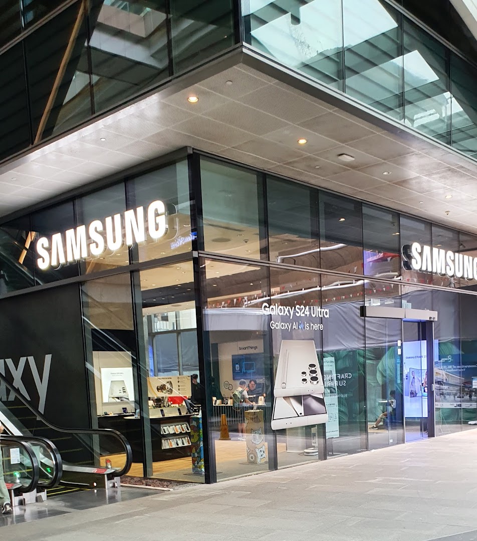 The modern glass exterior of a Samsung Experience Store, showcasing prominent branding and product displays.