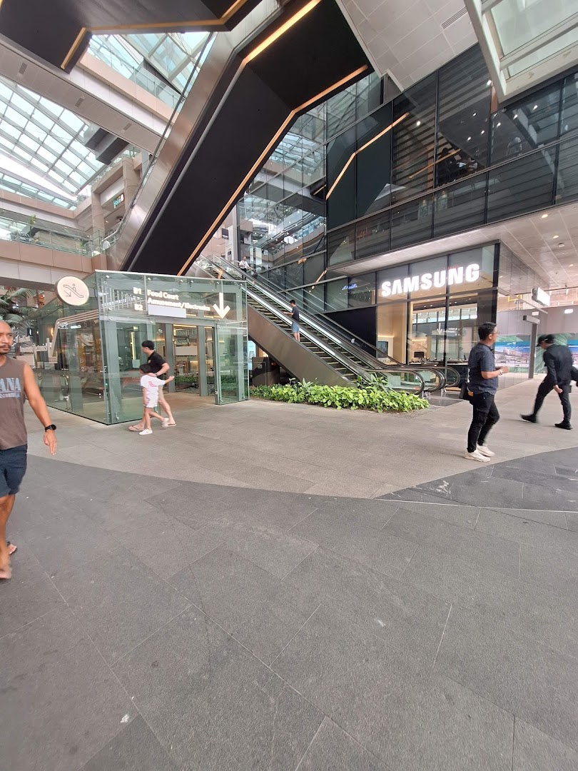 The Samsung Experience Store entrance is visible within a modern shopping mall, featuring escalators and glass architecture.