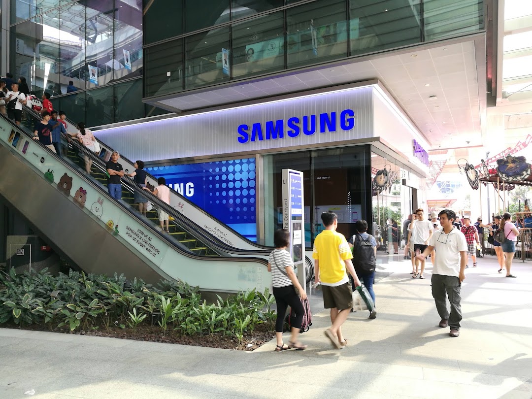 Exterior view of Samsung Service Centre Westgate, featuring its entrance, an escalator, and shoppers.