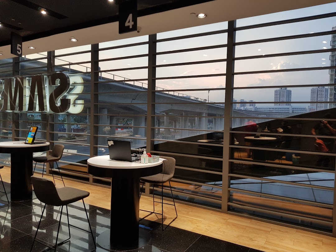 Interior of Samsung Service Centre featuring modern tables, chairs, and a large window view.