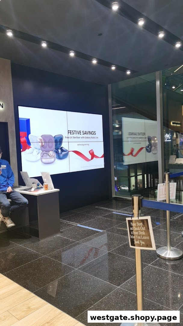 Interior view of Samsung Service Centre featuring a large display screen and a staff member.