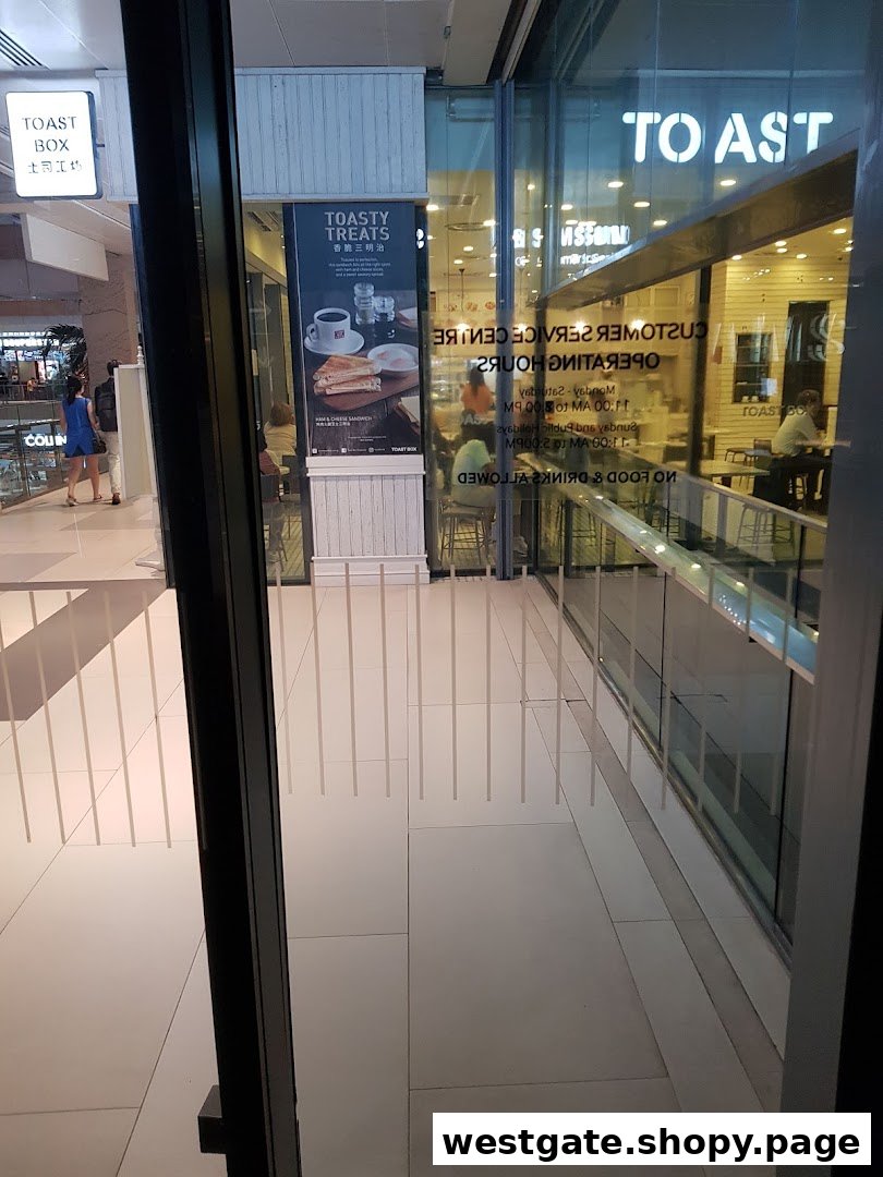 The shop front of Toast Box, a Singaporean coffee shop, showcasing its entrance and a 'Toasty Treats' poster.
