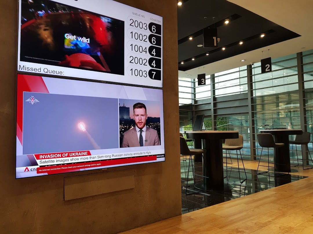 Interior view of a Samsung Service Centre with a queue display and customer service counters.