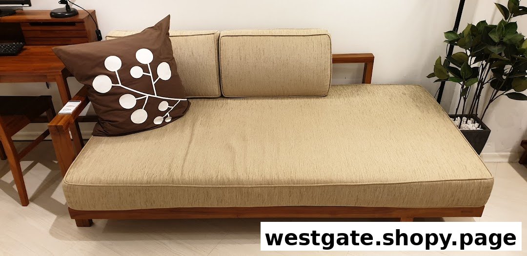 A stylish wooden daybed with light-colored cushions and a brown decorative pillow.