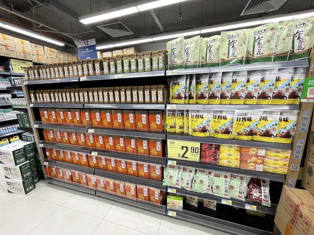Shelves in a supermarket aisle displaying a variety of packaged teas, health drinks, and traditional Chinese products.
